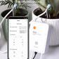 WiFi smart watering controller beside phone showing timed watering settings