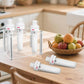 Square acrylic storage rack with stainless posts holding six white Cirkul bottles