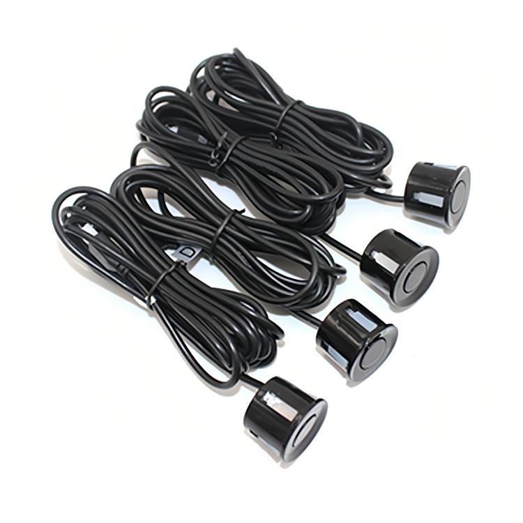 Four round parking sensors with black cables for car reversing radar system