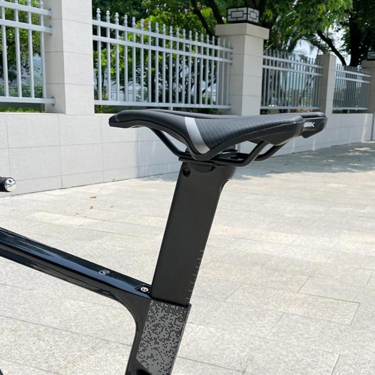 Carbon fiber road bike seatpost installed with black saddle and clamp head