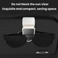 Car sun visor glasses clip holding black sunglasses, with white mounting strap.