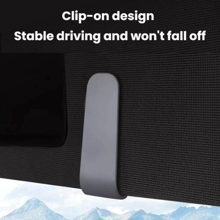 Gray car sunglasses clip ticket and card holder clipped onto car seat edge.