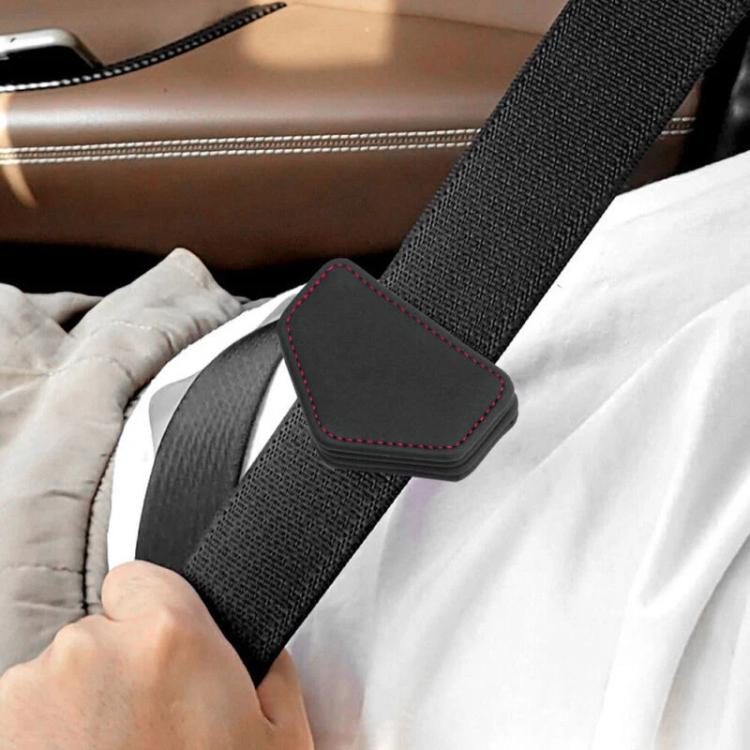 Car seat belt tension limiter pad on seat belt strap, black with red stitching