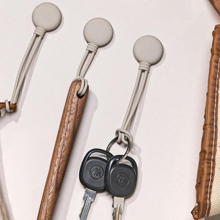 Two silicone cable organizers holding cords with loop ends and metal keys