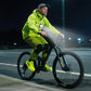 Cyclist wearing a green chest warning light with white front lamp and red LEDs