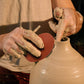 Pottery sculpting needle tools with wooden handles, shaping clay on a vase