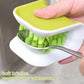Hand using a green-bristle knife scrub brush on tableware