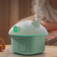Green mini house desktop humidifier with glowing green window, mist rising