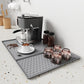 Gray silicone draining tray mat with raised horizontal ridges for coffee machine