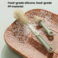 Green silicone bottle brush with two bristle heads on a wooden surface