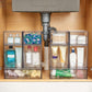 Clear multi-bin perfume storage rack with compartments for skincare bottles and jars