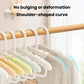 Kids retractable hangers on a wooden bar; curved shoulders with white and light green arms.