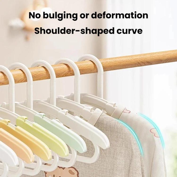 Kids retractable hangers on a wooden bar; curved shoulders with white and light green arms.