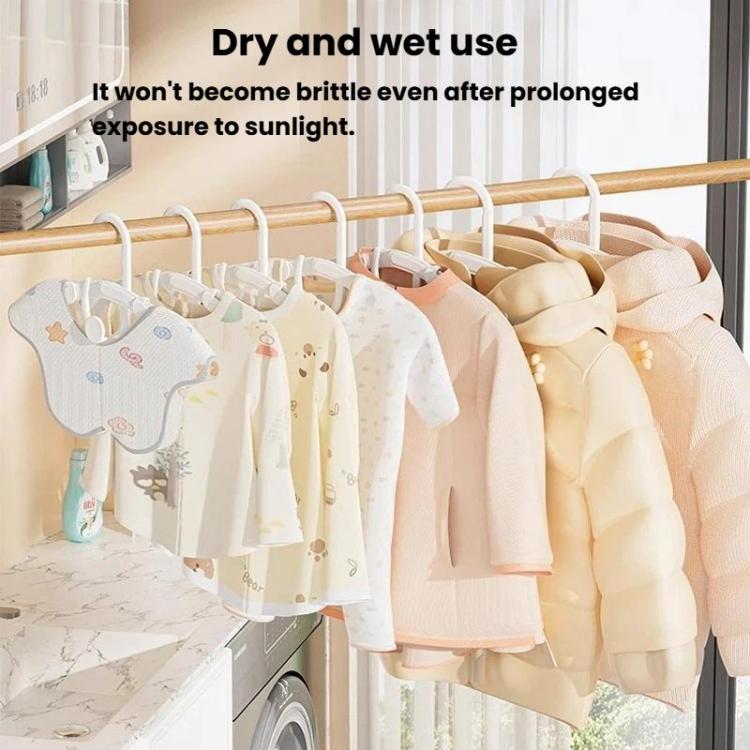 Retractable kids hangers holding small shirts and outfits on a clothing rack, mixed neutrals.