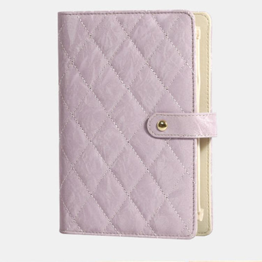 Lavender quilted jewelry organizer book with snap strap and cream interior backing.