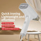 White handheld garment steamer steaming fabric on a table, compact foldable design