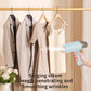 Handheld garment steamer emitting steam toward hanging shirts on a clothing rack