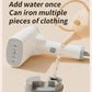 White garment steamer with water added, pouring steam while ironing multiple clothes