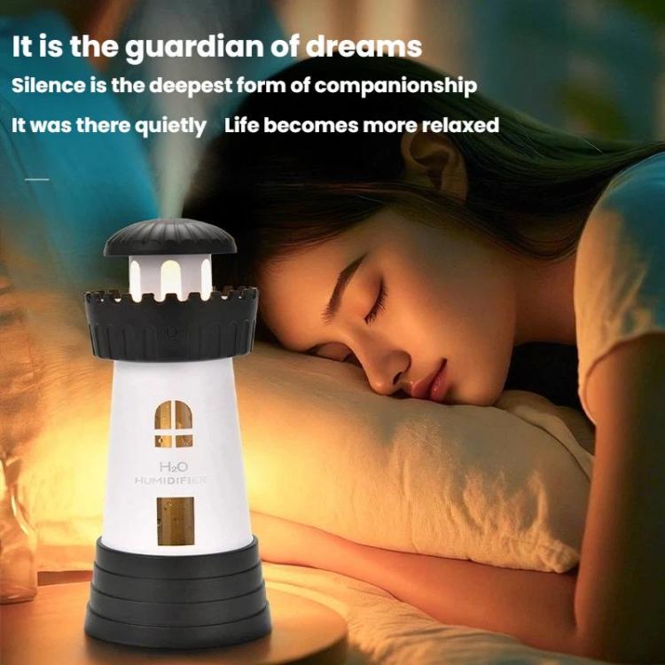 Dark gray lighthouse-shaped humidifier with illuminated windows on a nightstand