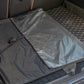 Gray waterproof folding trunk mat with black border and corner straps