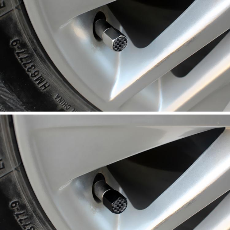 Close-up of black carbon-textured valve stem cap on a car wheel rim