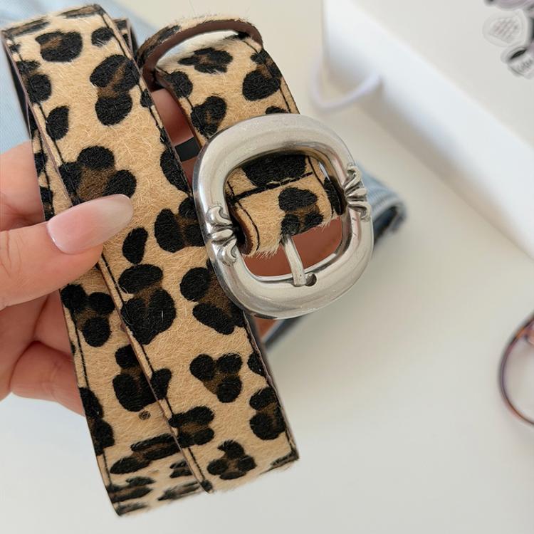 Leopard print fabric belt, close-up of silver oval buckle on tan strap
