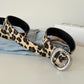 Leopard print belt worn with light denim, silver buckle fastening