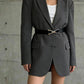 Black waist belt with gold triangle buckle worn at the waist