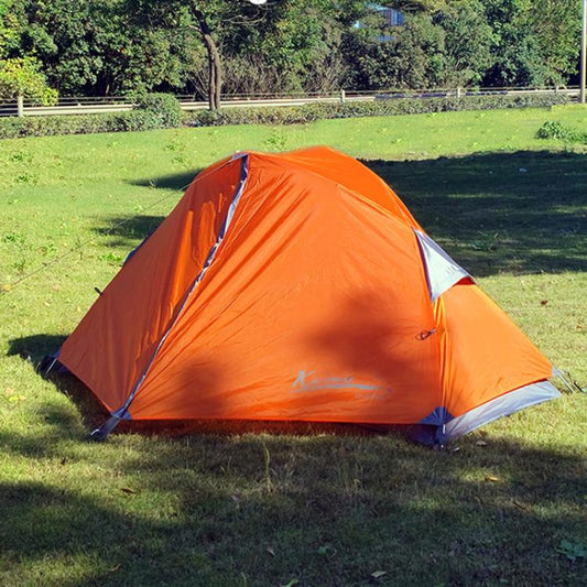 Orange dome camping tent with front doorway and guy lines on grass
