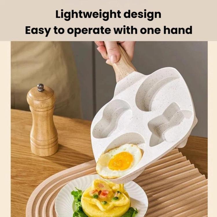 Beige four-hole nonstick frying pan with one egg in a cup, wooden handle