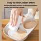 Beige four-hole nonstick frying pan being cleaned with a paper towel