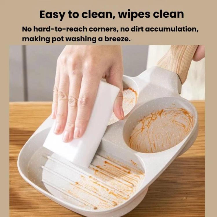 Beige four-hole nonstick frying pan being cleaned with a paper towel