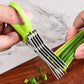 Hands using green-handled multi-blade kitchen scissors to cut green onions