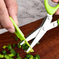 Close-up of green-handled multi-blade scissors slicing green onions