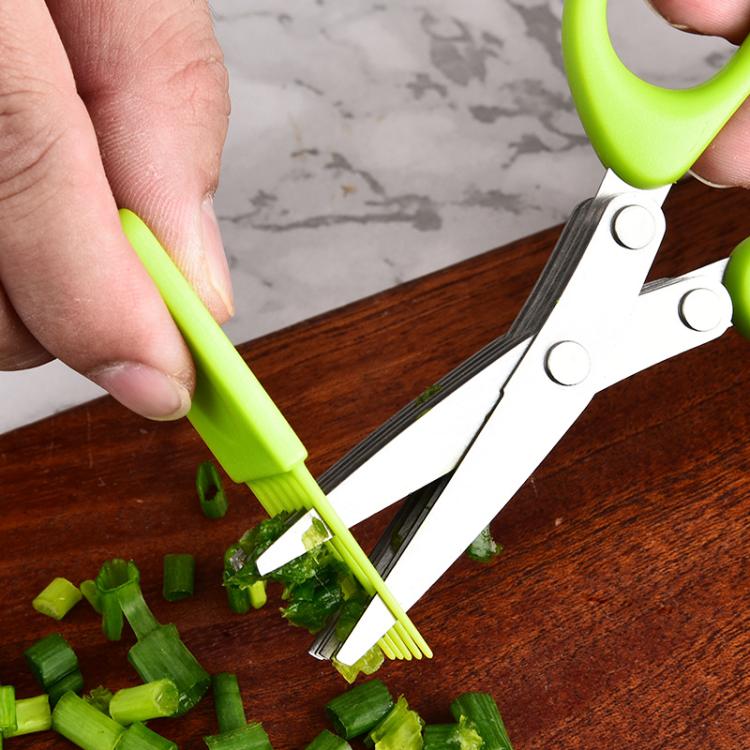 Close-up of green-handled multi-blade scissors slicing green onions