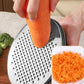 Carrot being grated on stainless steel grater disc with shredded carrot in cup