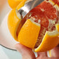 Close-up of stainless steel peeler blade slicing orange segments
