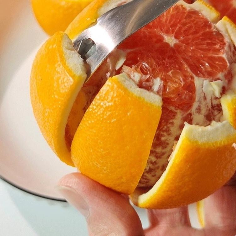 Close-up of stainless steel peeler blade slicing orange segments