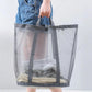 Gray mesh laundry hamper with handles holding folded clothes in the basket
