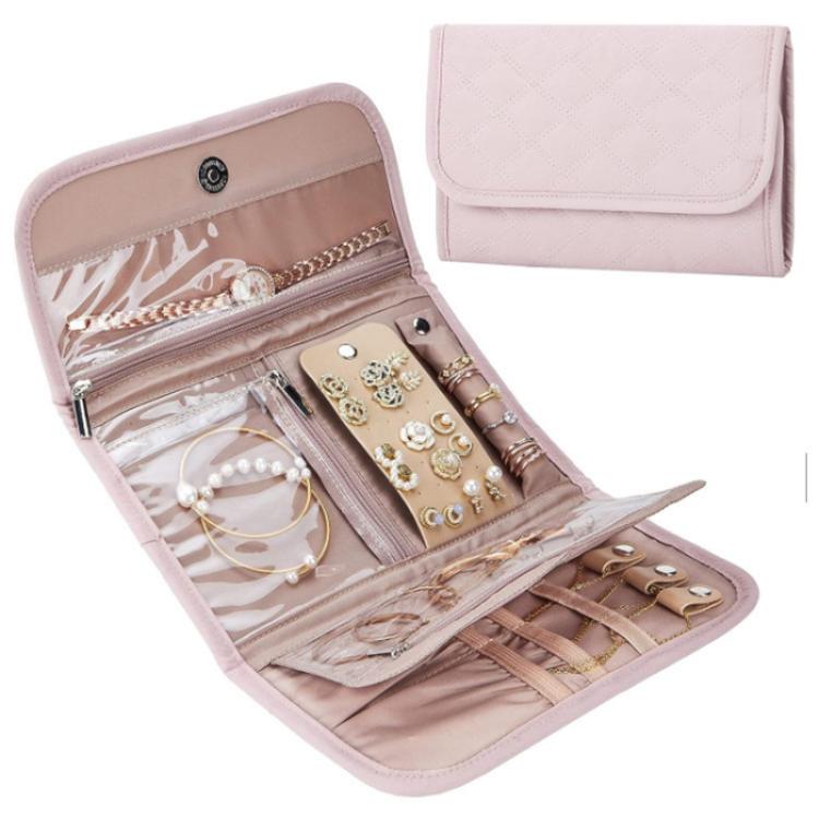 Pink faux-suede jewelry storage roll bag with snap flap, open slots for earrings