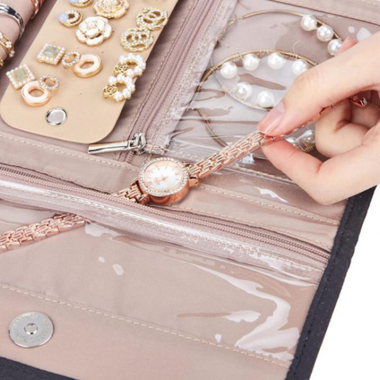 Pink faux-suede jewelry roll bag with zip compartments holding bracelets and earrings