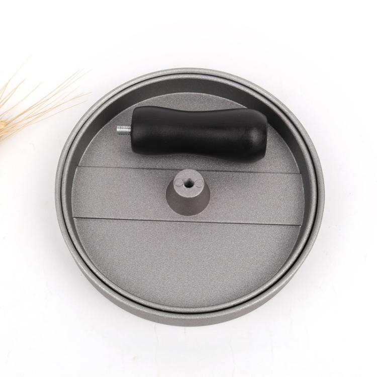 Hamburger patty mold press lid with black handle knob and central post on gray base