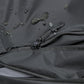 Black waterproof fabric close-up with raindrop texture and zipper closure