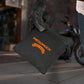 Black waterproof helmet backpack on the floor with front pocket and logo patch