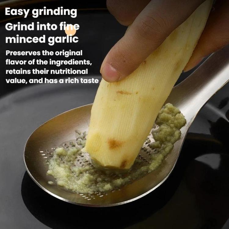 Manual ginger garlic grinder spoon mashing minced ginger and garlic in a bowl
