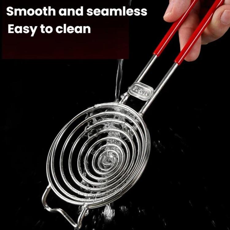 Stainless steel spiral strainer with red handle, rinsed under water for easy cleaning