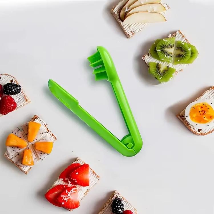 Green fruit slicer with cutting prongs, shown with sliced fruit pieces