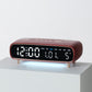 Burgundy digital alarm clock with date, weekday, temperature, and time display on front