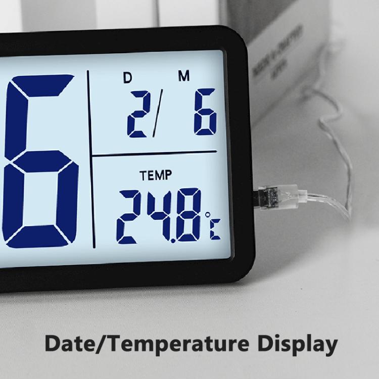 Close-up of black LCD digital clock showing time and temperature on screen