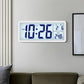 White LCD digital clock mounted on wall with blue time and temperature display